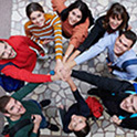 group of people in a circle with their hands in the middle