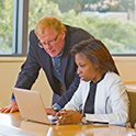 two peopel looking at a computer