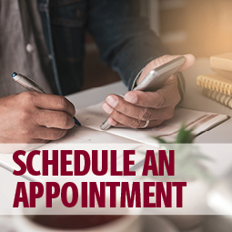 image of a person on their phone and writing on a calendar. text over image says "schedule an appointment"