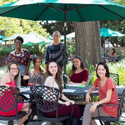 A group of people at a table outside.