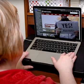 Student using a laptop using assistive technology. 