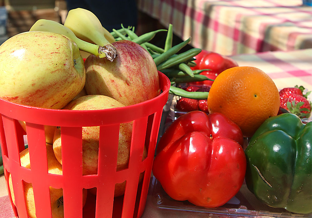 Baskets of fruits and veggies sitting on a table.