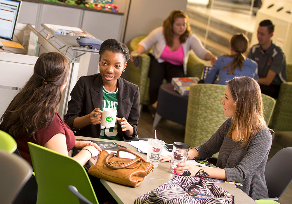 Group of students gathered together at a table. 