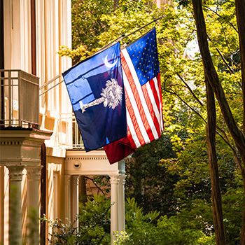 The South Carolina flag and the United States of America flag hanging on the side of the President's House. 