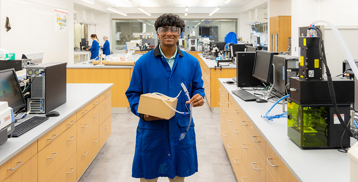 a man with a device posing in a lab