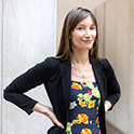 woman standing outside with flower dress on smiling