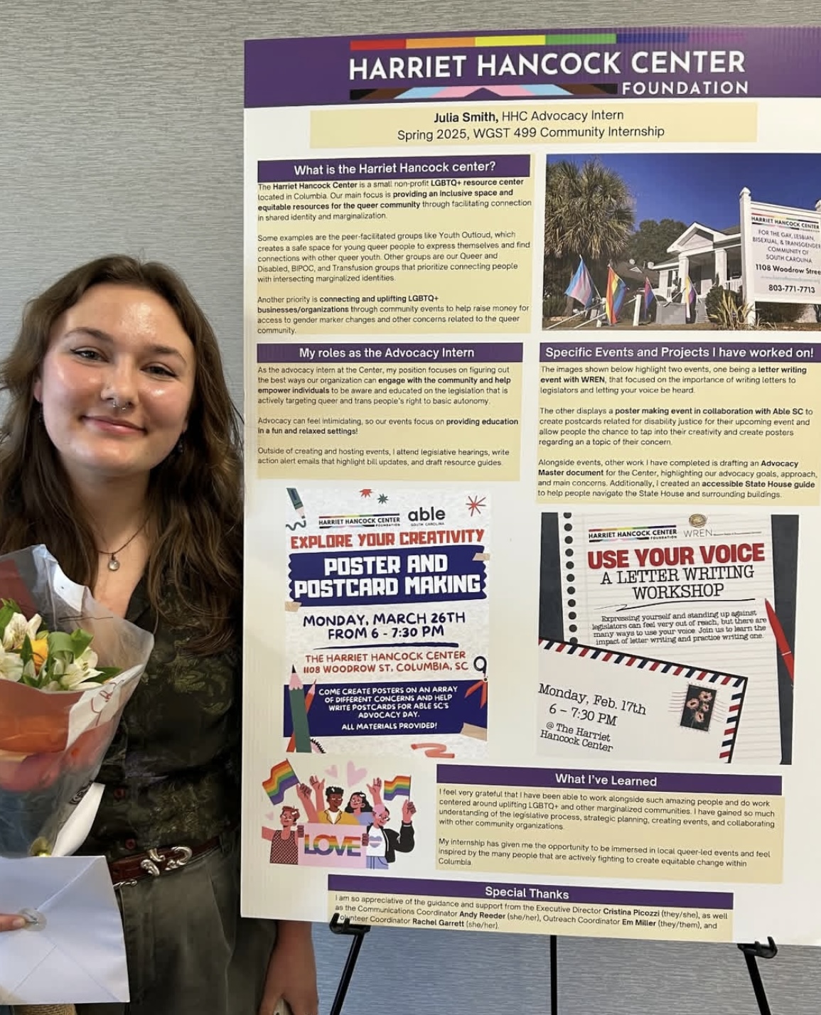 A student stands beside a large poster summarizing their advocacy internship at the Harriet Hancock Center.