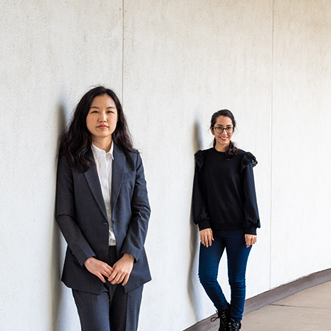 two female student pose socially distanced