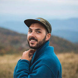 Zachary Brinchi headshot with mountains in the background