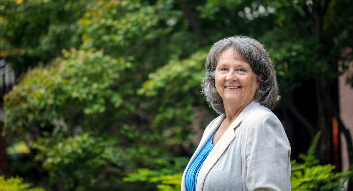 woman standing outside with trees in the background