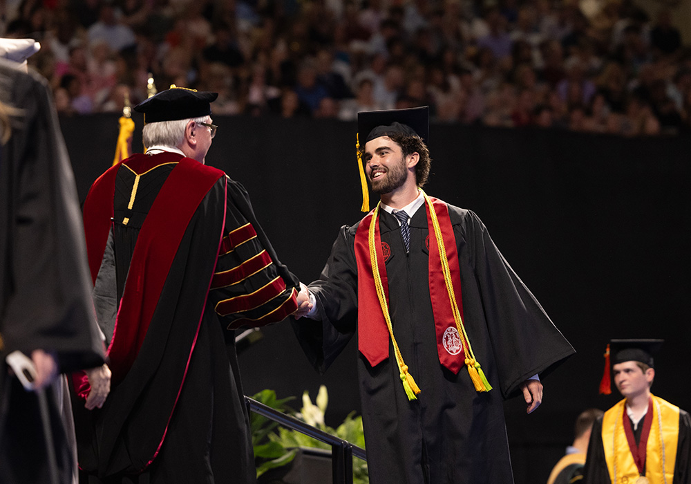 graduating student shaking hands on stage