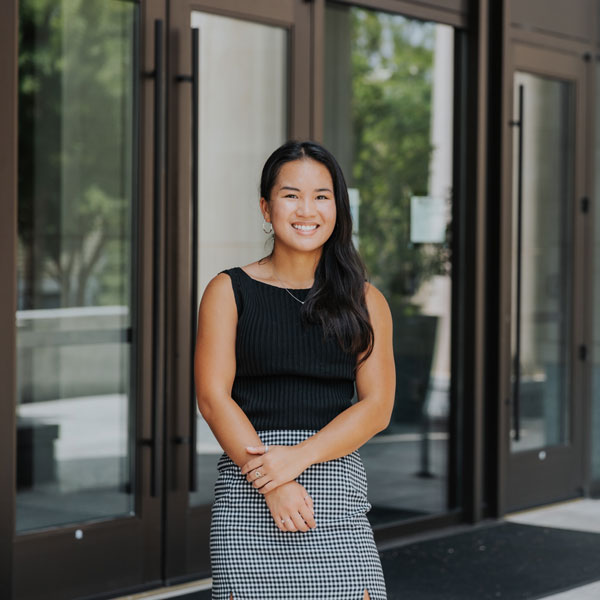 woman standing in front of the Joseph F. Rice School of Law 