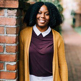 UofSC student Rodriana Gaddy by a brick wall