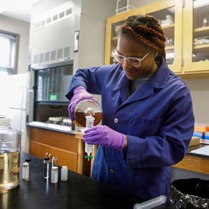 Student pours liquid into beaker