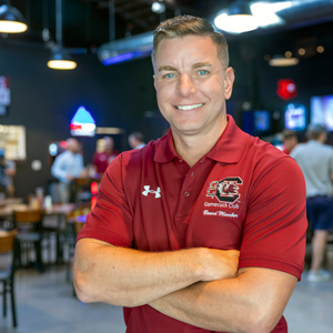 James wolf stands in a restaurant wearing a gamecock club golf shirt