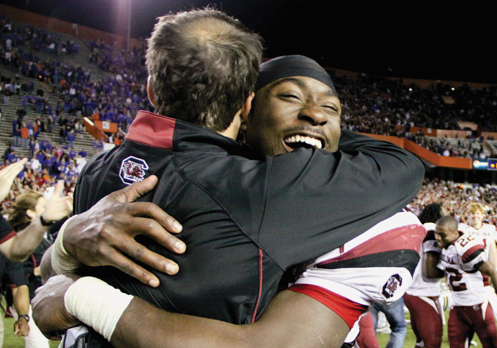 Shane Beamer embraces Marcus Lattimore on the field.