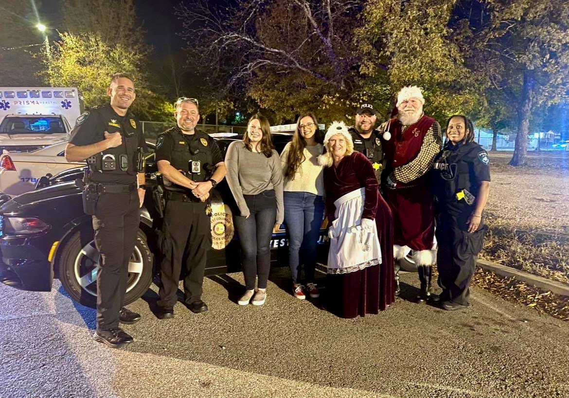 COSW alumni and LEAD program developers post with West Columbia Police Officers during a holiday event. 