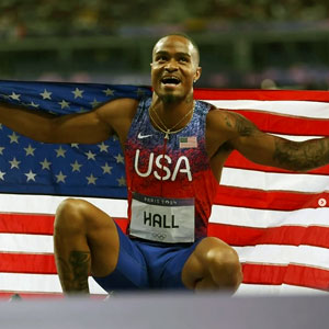 man in track suit holds US flag